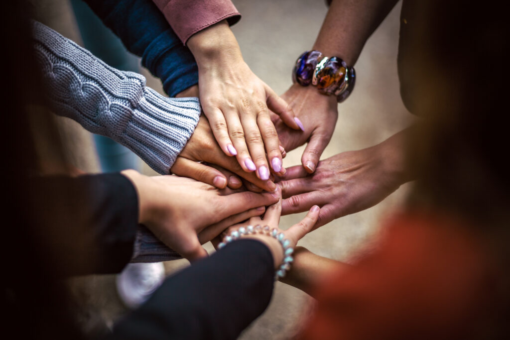 Mehrere Hände sind in der Mitte aufeinander gelegt